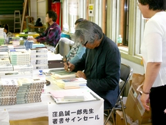 写真 講演終了後サインセールを行う窪島さん