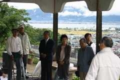 写真　雨の中あずまやで碑前蔡を行う